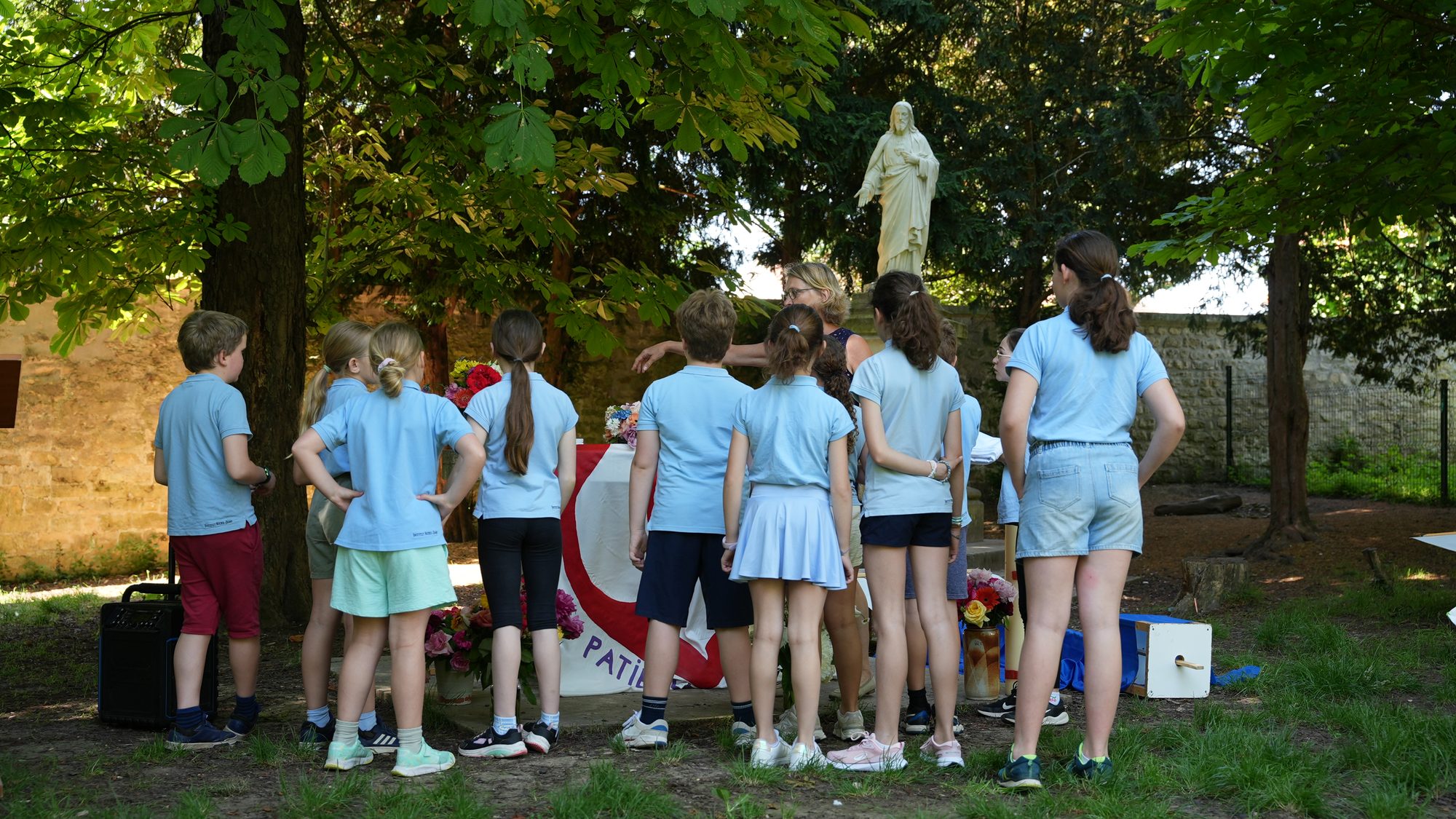 Des écoliers rassemblés devant la statue de la Vierge lors d’un temps de prière