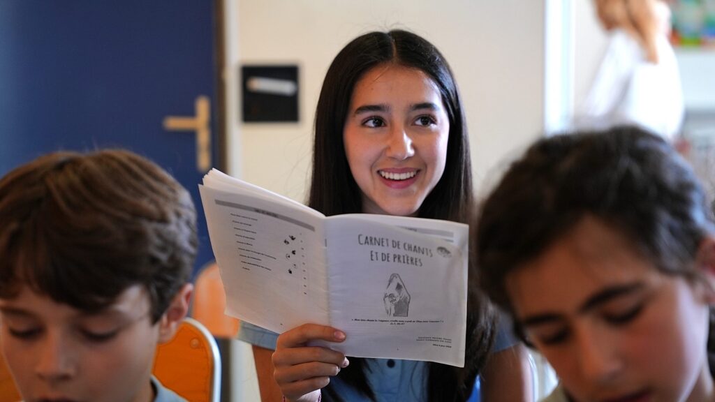 Une lycéenne lit un livret devant ses camarades